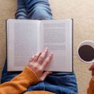 CAMACOES. Persona leyendo un libro y bebiendo café. 3 libros que debe leer antes de que acabe el 2023, según McKinsey