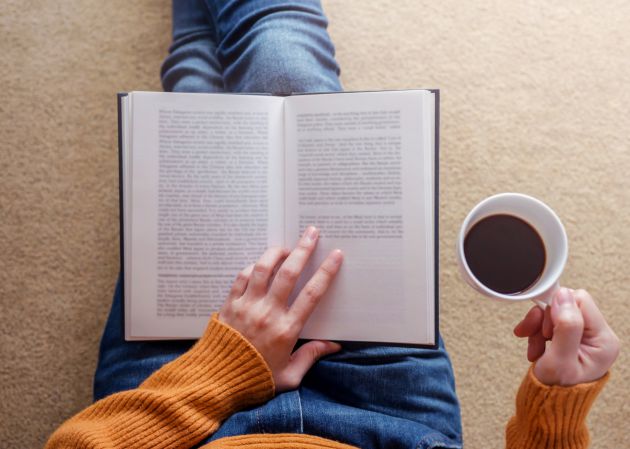 CAMACOES. Persona leyendo un libro y bebiendo café. 3 libros que debe leer antes de que acabe el 2023, según McKinsey